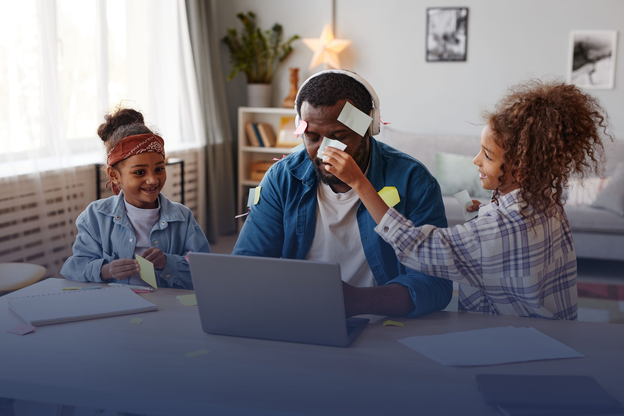 A father works from home, his children are distracting him. His laptop is not secure which could pose a security risk to company data.